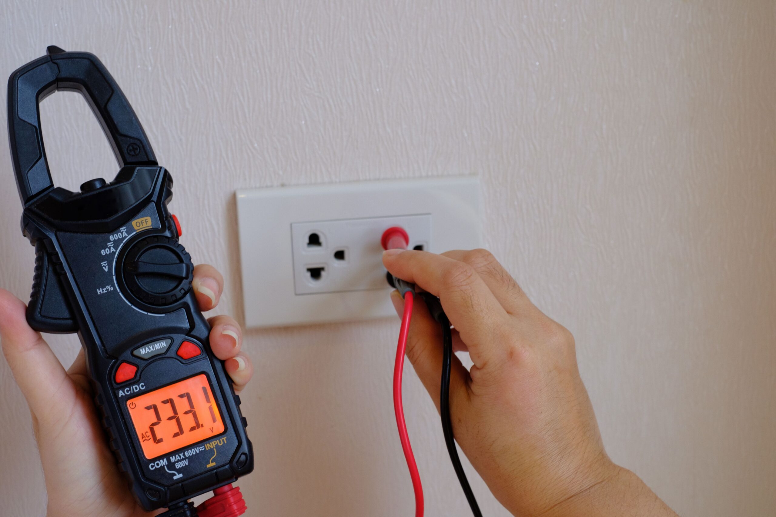 Licensed electrician in Balmain East inspecting power outlet using a tester