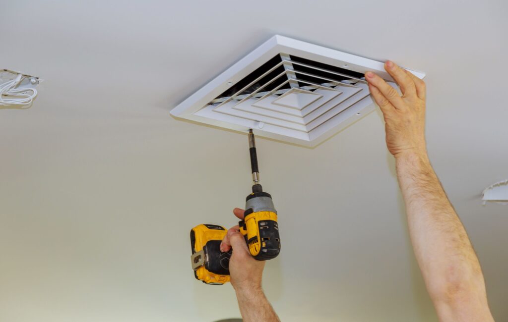 A licensed electrician removing bathroom vent cover in Birchgrove
