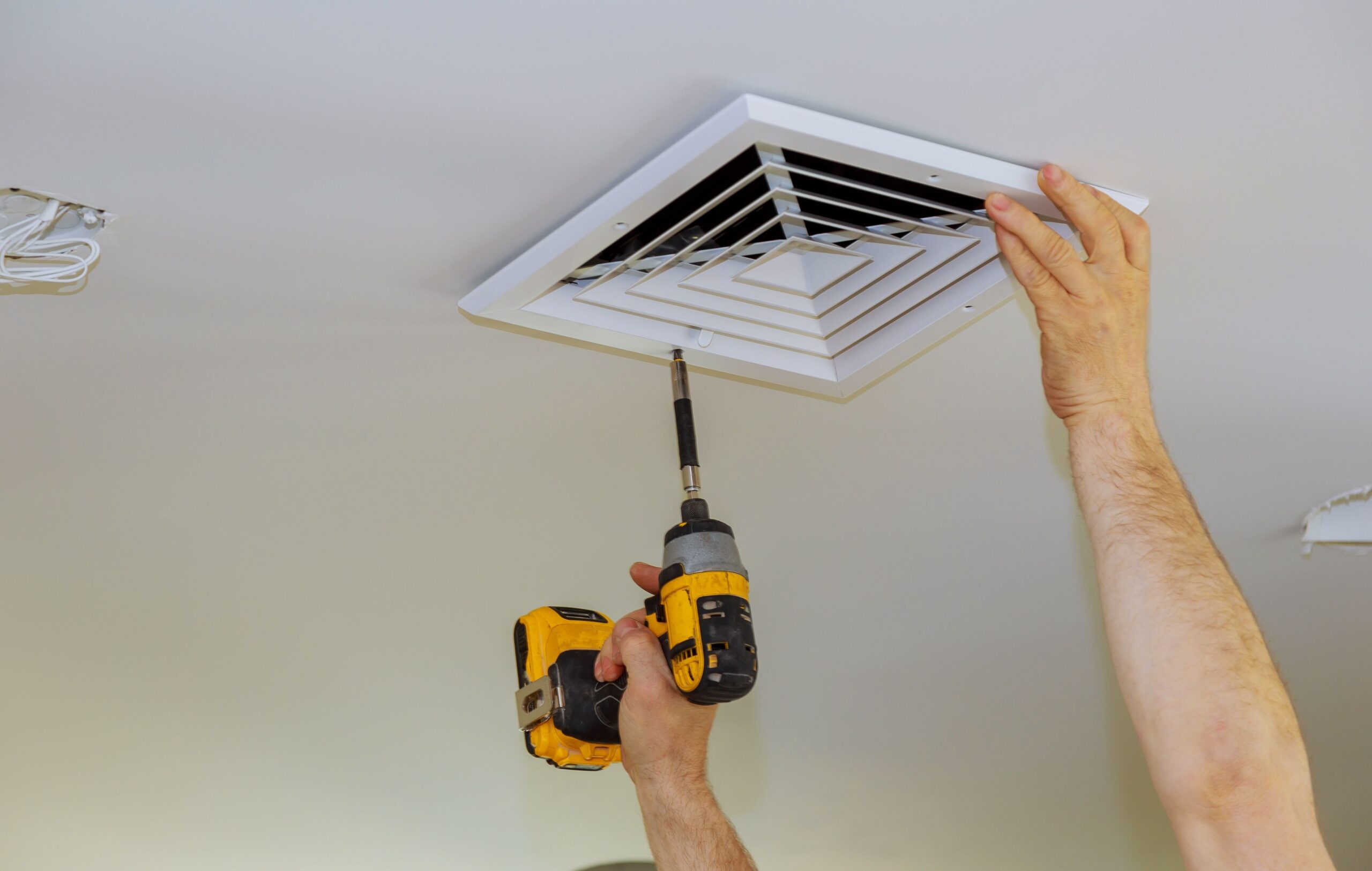 A licensed electrician removing bathroom vent cover in Birchgrove